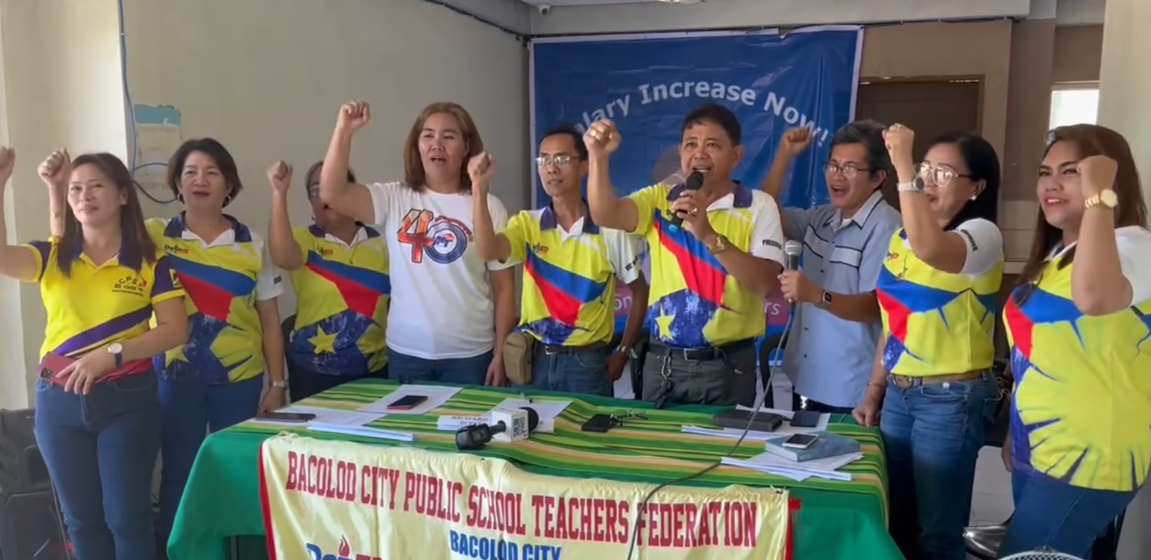 Nine Bacolod City teachers raising their fist in demand to increase salary.